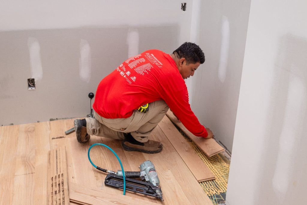 Santi Hardwood Floors installer preparing board at workbench