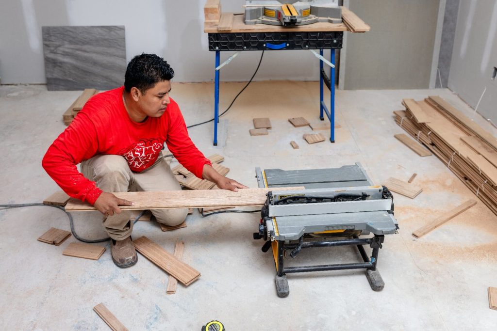 Installer fitting hardwood board during subfloor prep, Durham NC